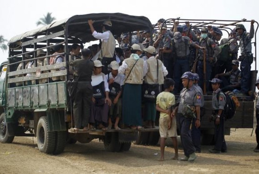 Volunteers and police board vehicles before proceeding to Rohingya refugee camps to collect data for the census in Sittwe March 31, 2014.
