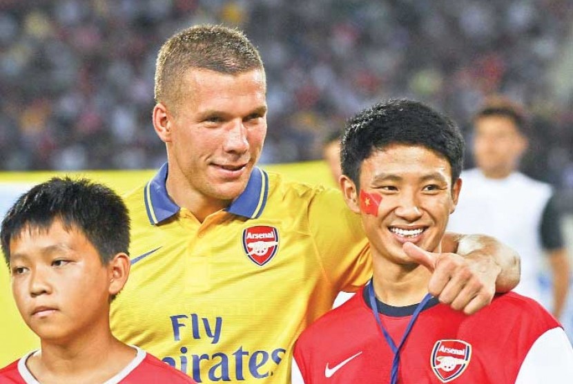 Vu Xuan Tien (kanan) bersama pemain Arsenal Lukas Podolski.
