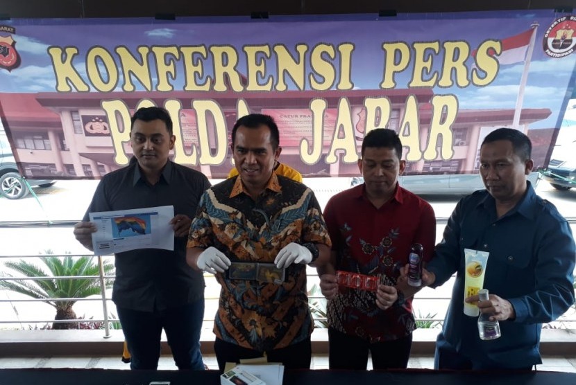 Wadir Krimsus Polda Jabar, AKBP Hari Brata (tengah) menunjukkan barang bukti dalamnkasus grup Gay Bandung Indonesia (GBI) yang beranggotakan 4.093 orang. 