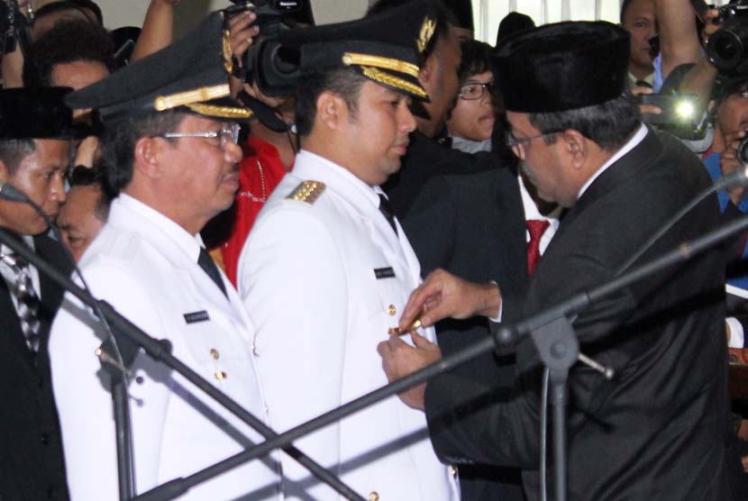  Wagub Banten Rano Karno (kanan) menyematkan emblem kepada walikota terpilih Arief R Wismansyah (dua kiri) dan wakil walikota Syachrudin (kiri) dalam acara Pelantikan di Gedung DPRD Kota Tangerang, Banten, Selasa (24/12).  (Antara/Muhammad Iqbal)