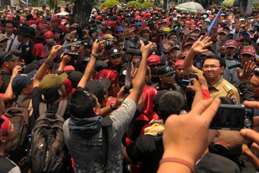 Wagub DKI Jakarta, Basuki Tjahaja Purnama atau Ahok (kanan) menyapa para buruh yang menggelar aksi unjuk rasa di depan Gedung Balai Kota, Jakarta, Rabu (24/10). Para buruh menuntut upah layak dan mendesak Pemerintah DKI Jakarta, untuk menghapuskan sistem 