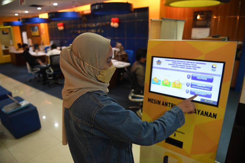 Wajib pajak mengambil nomor antrean di salah satu kantor pelayanan pajak pratama di Jakarta.