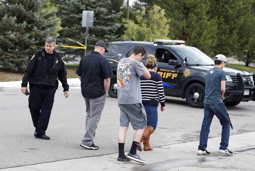 Wakil Departemen Sheriff Douglas County, Denver, Colorado mengarahkan warga kembali ke kendaraan di luar STEM School Highlands Ranch setelah terjadi penembakan di sekolah tersebut, Selasa (7/5).