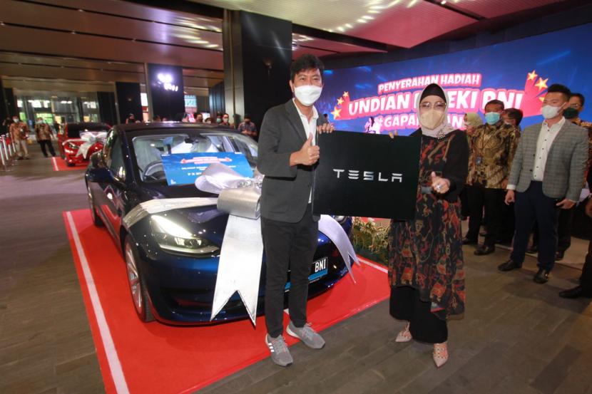  Wakil Direktur Utama BNI Adi Sulistyowati bersama pemenang hadiah grand prize Mobil listrik mewah Tesla Model 3 Ryan di Menara BNI Pejompongan, Kamis (24/3/2022). 
