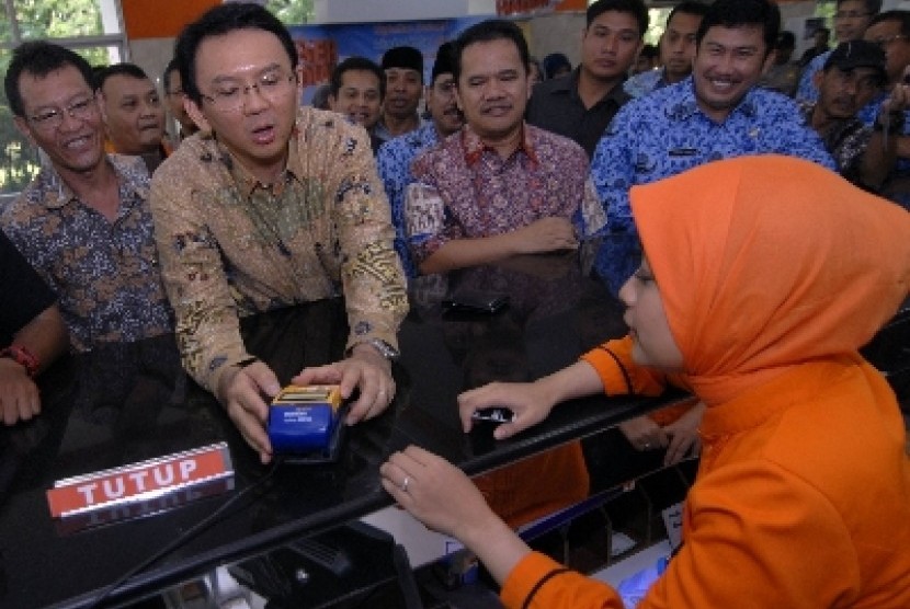 Wakil Gubernur DKI Jakarta Basuki Tjahaja Purnama (kedua kiri) melakukan transaksi pembayaran Pajak Bumi dan Bangunan (PBB) di Kantor Pos Pasar baru, Jakarta