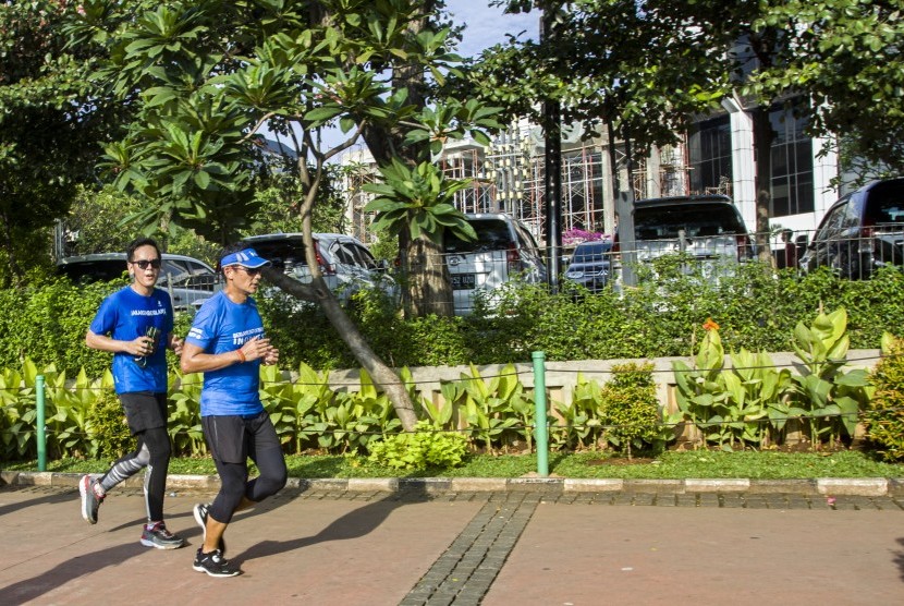 Wakil Gubernur DKI Jakarta Sandiaga Uno (kanan) berlari menuju Balai Kota, di Jakarta, Jumat (20/10). 