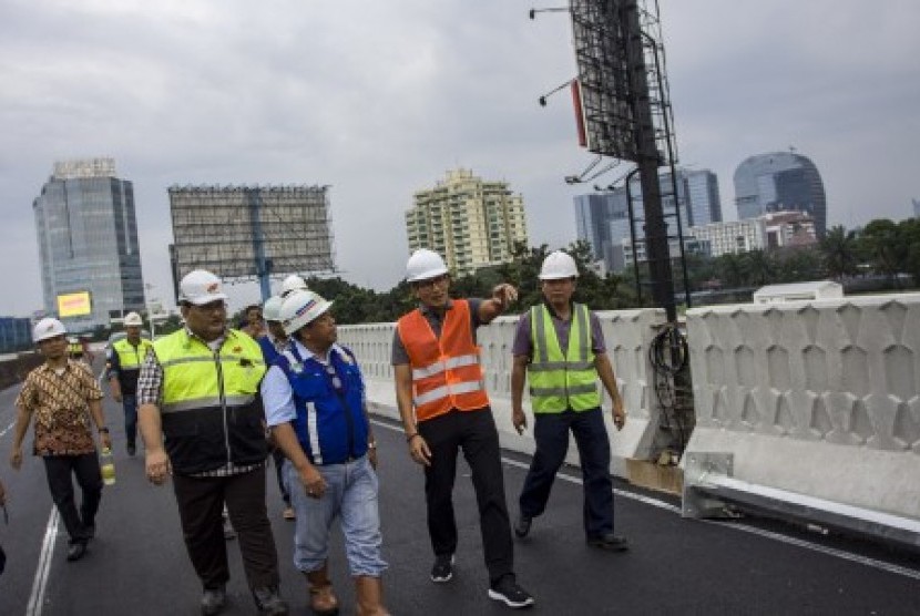 Wakil Gubernur DKI Jakarta Sandiaga Uno (kedua kanan) bersama Kepala Dinas Bina Marga DKI Jakarta Yusmada Faizal (kanan) dan Kepala Bidang Simpang dan Jalan Tak Sebidang Dinas Bina Marga DKI Jakarta Heru Suwondo (ketiga kanan) meninjau proyek pembangunan jalan layang Pancoran, di Jakarta, Sabtu (30/12). Peninjauan tersebut untuk mengecek progres pembangunan flyover atau jalan layang yang ditargetkan selesai pada 31 Desember 2017 namun meleset hingga pertengahan Januari 2018 karena terkendala cuaca dan struktur box girder yang bermasalah. 