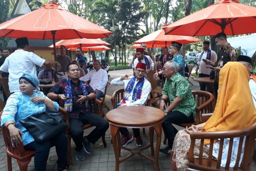 Wakil Gubernur DKI Jakarta Sandiaga Uno (tengah memakai peci merah) sedang duduk menghadiri Peresmian Kampung Betawi di Pasar Seni Taman Impian Jaya Ancol, di Jakarta Utara, Rabu (13/6).