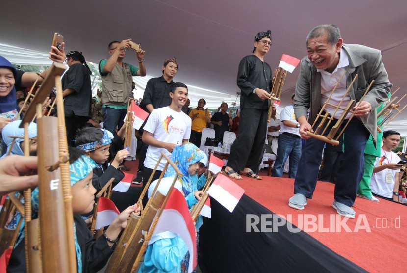  Wakil Gubernur Jabar Deddy Mizwar bersama ribuan pelajar memainkan angklung pada Angklungs Day 2017 di halaman Gedung Sate, Kota Bandung, Ahad (19/11).