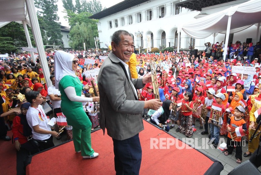 Wakil Gubernur Jabar Deddy Mizwar bersama ribuan pelajar memainkan angklung pada Angklungs Day 2017 di halaman Gedung Sate, Kota Bandung, Ahad (19/11).