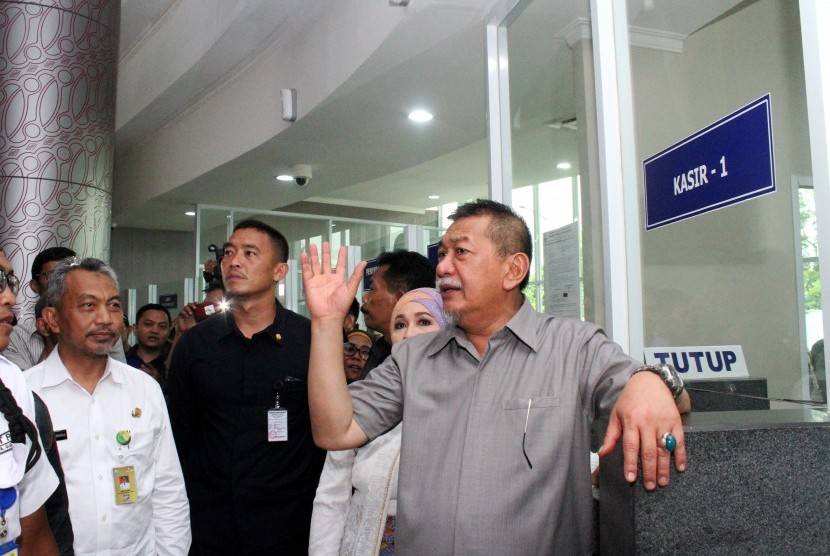 Wakil Gubernur Jawa Barat Deddy Mizwar (kanan) didampingi Wakil Wali Kota Bekasi Ahmad Syaikhu (kiri) meninjau loket pelayanan pajak kendaraan usai meresmikan Kantor Samsat Kota Bekasi, di Bekasi, Jawa Barat, Selasa (16/5).