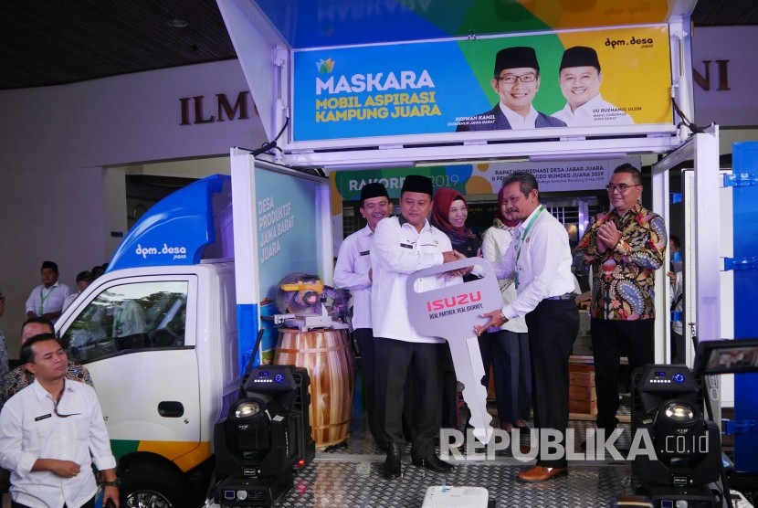 Wakil Gubernur Jawa Barat Uu Ruzhanul Ulum (kiri) secara sembolis menyerahkan kunci mobil maskara kepada salah satu kabupaten saat peluncuran Mobil Aspirasi kampung Juara (Maskara). 