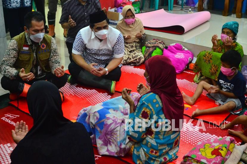 Wakil Gubernur Jawa Tengah Taj Yasin Maimoen (kedua kiri) berdoa bersama korban banjir di tempat pengungsian Desa Karangrowo, Undaan, Kudus, Jawa Tengah, Rabu (10/2/2021). Banjir yang merendam tiga kecamatan di kabupaten Kudus lebih dari sepekan itu mengakibatkan sebanyak 858 jiwa diungsikan.