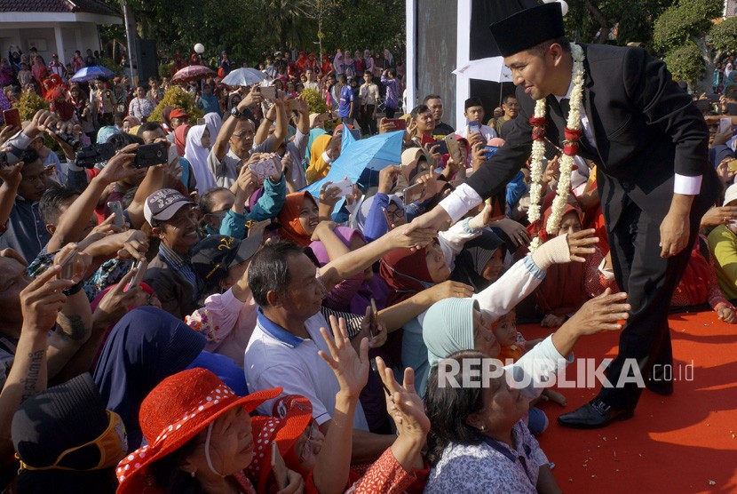 Wakil Gubernur Jawa Timur Emil Elestianto Dardak (kanan) berjabat tangan dengan warga saat kunjungan kerja di Kabupaten Trenggalek, Jawa Timur, Jumat (15/2/2019).