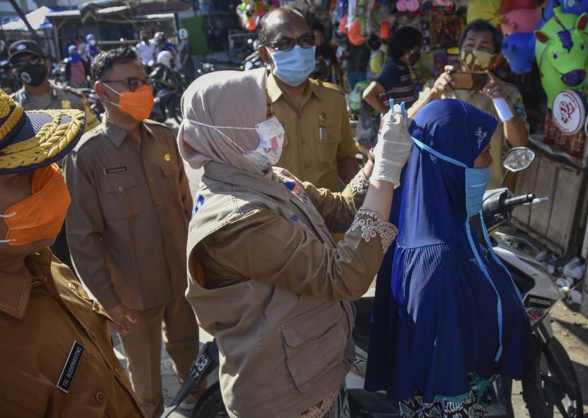 Wakil Gubernur NTB Sitti Rohmi Djalilah (tengah) memakaikan masker kain kepada pengunjung di Pasar Tradisional ACC Ampenan, Mataram, NTB.  Provinsi Nusa Tenggara Barat mulai memberlakukan sanksi bagi siapa saja yang tidak menggunakan masker sebagaimana yang tertuang dalam Perda Nomor 7 Tahun 2020 tentang Penanggulangan Penyakit Menular.