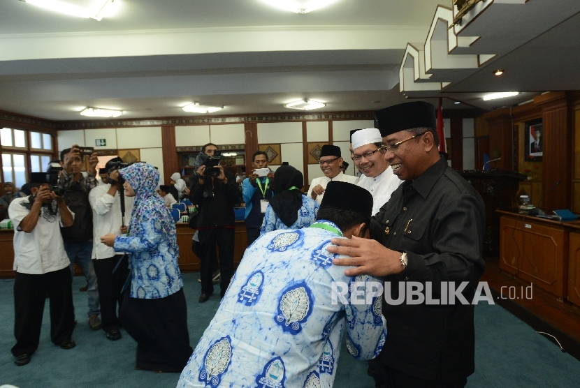 Wakil Gubernur Nusa Tenggara Barat (NTB) Muhammad Amin (kanan) menyalami kafilah dari NTB seusai menghadiri acara pelepasan di kantor gubernur NTB, Jumat (29/7).