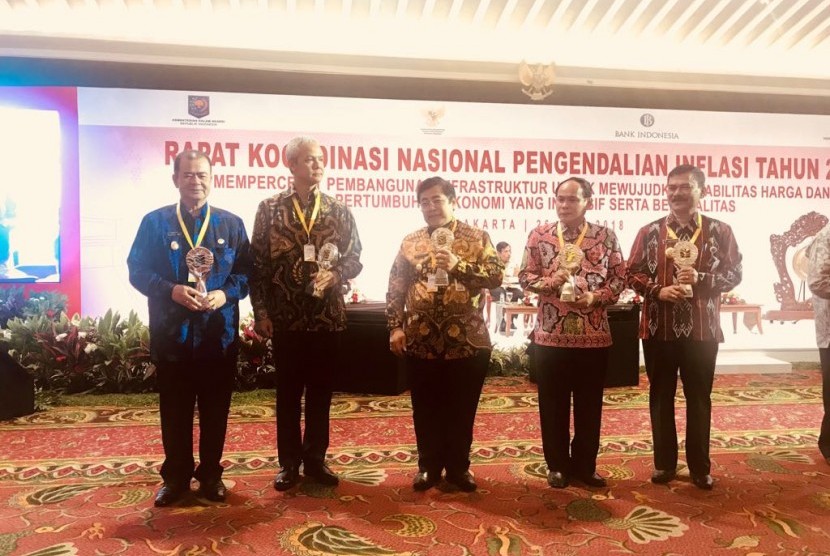 Wakil Gubernur Sumbar Nasrul Abit (kiri), mewakili Gubernur Sumbar, menerima penghargaan TPID Terbaik Provinsi di Kawasan Sumatra 2017.