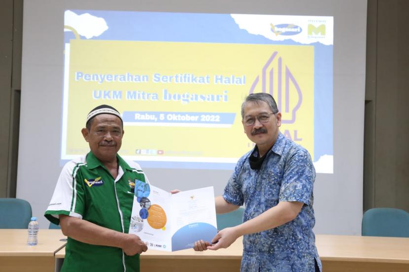 Wakil Kepala Divisi Bogasari Erwin Sudharma (kanan) menyerahkan Sertifikat Halal dari BPJH kepada UKM Mie Basah Darmanto  (kiri) asal Jakarta Utara,  satu dari 45 UKM Mitra Bogasari yang dapat sertifikat halal, di pabrik Bogasari, Jakarta.