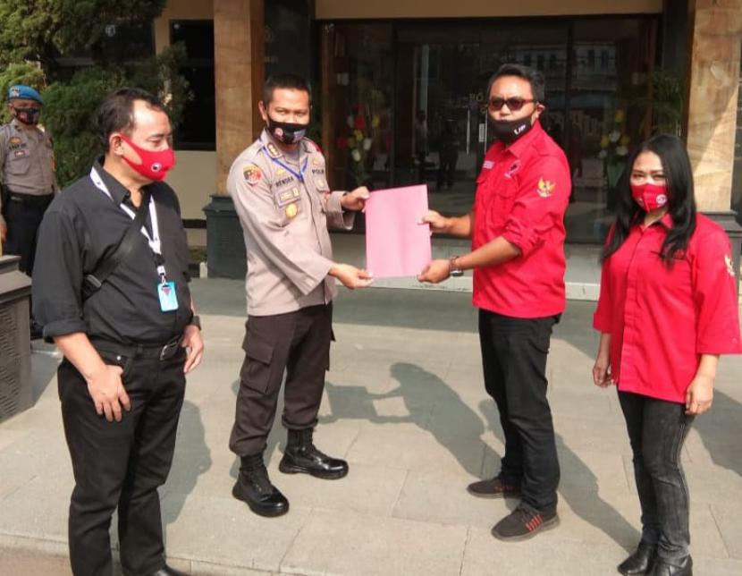 Wakil Ketua Bidang Hukum DPC PDIP Kabupaten Bandung Nanang Parhan SH (kedua kanan) menyerahkan berkas laporan atas aksi pembakaran bendera PDIP di Mapolresta Bandung, Kecamatan Soreang, Kabupaten Bandung, Jumat (26/6). 