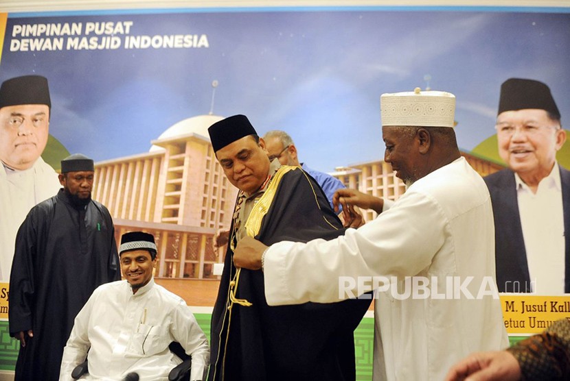 Wakil Ketua Dewan Masjid Indonesia yang juga menjabat Wakapolri Komisaris Jenderal Pol Syafruddin  menerima baju gamis dari ulama Mekkah, Saudi Arabia, Syekh Kahlid Al Hamoudi saat pertemuan di kantor DMI Pusat, Jakarta, Senin (2/4). 
