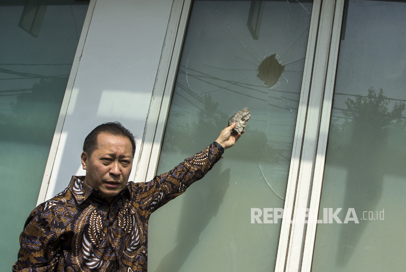 Wakil Ketua DPP PPP Humphrey Djemat menunjukkan barang bukti batu dan kaca yang rusak akibat penyerangan oleh orang tak dikenal di Kantor DPP PPP kubu Djan Faridz, jalan Diponegoro, Jakarta, Minggu (16/7).
