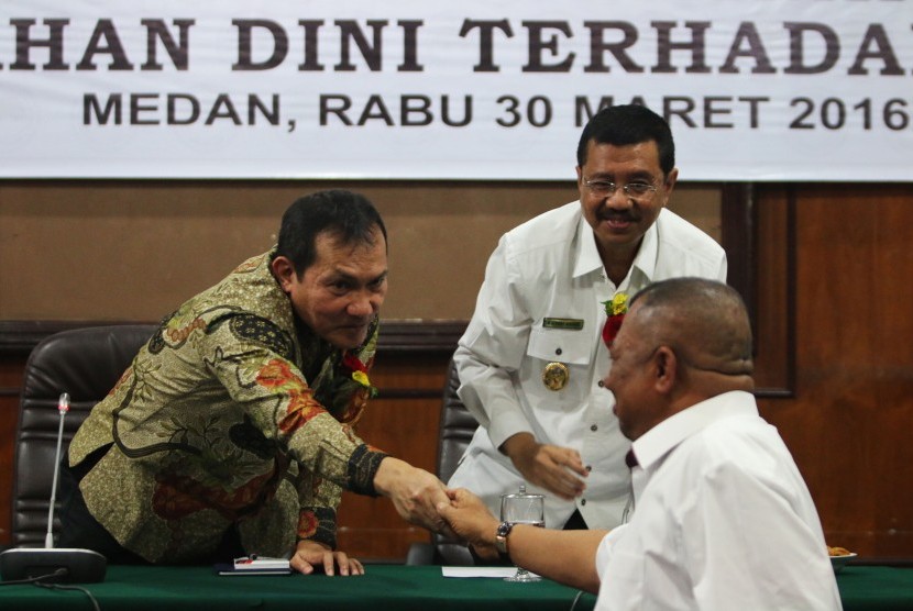 Wakil Ketua Komisi Pemberantasan Korupsi (KPK) Saut Situmorang (kiri) disaksikan Plt Gubernur Sumatra Utara T Erry Nuradi (kanan) menyalami mantan Gubernur Sumatra Utara Syamsul Arifin di sela-sela Seminar Pencegahan Dini Terhadap Korupsi di Medan, Sumatra