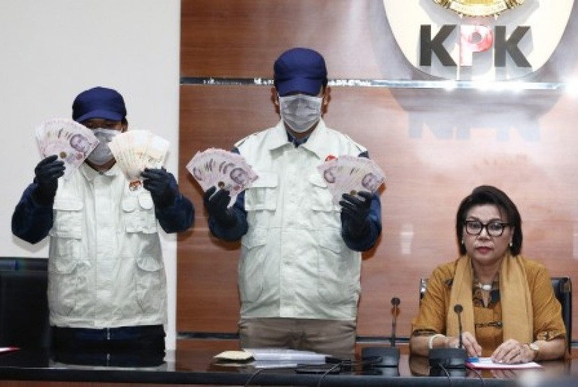 Wakil Ketua KPK Basaria Panjaitan (kanan) mendampingi petugas menunjukkan barang bukti seusai memberikan keterangan pers terkait Operasi Tangkap Tangan (OTT) Direktur Keuangan PT Angkasa Pura II di Gedung KPK, Jakarta, Kamis (1/8).