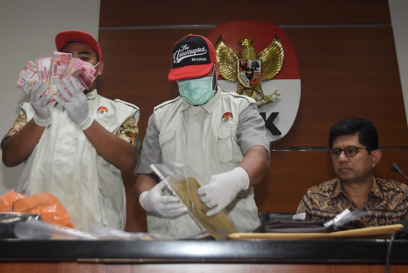 Wakil Ketua KPK Laode M. Syarief (kanan) bersama penyidik menunjukkan barang bukti hasil OTT kasus dugaan suap terkait seleksi pengisian jabatan pimpinan tinggi di Kementerian Agama saat konferensi pers di gedung KPK, Jakarta, Sabtu (16/3).