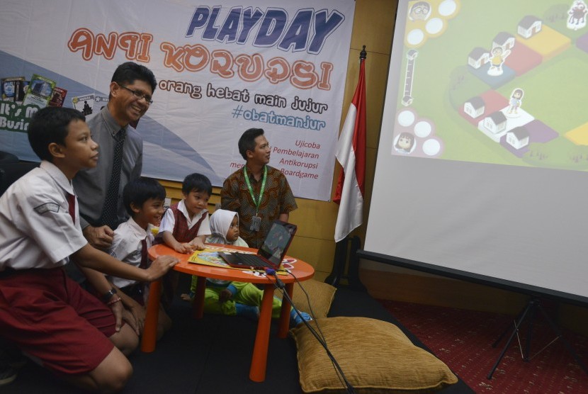 Wakil Ketua KPK Laode M. Syarif (kedua kiri) bersama anak-anak sekolah bermain dalam peluncuran Playday Boardgames Anti Korupsi di KPK, Jakarta, Jumat (15/4). (Antara/Rosa Panggabean)