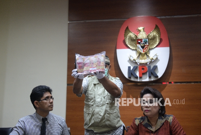 Wakil Ketua KPK Laode M Syarif (kiri) dan Basaria Panjaitan (kanan) bersama penyidik KPK menunjukkan uang barang bukti hasil OTT di Gedung KPK, Jakarta, Selasa (6/6).