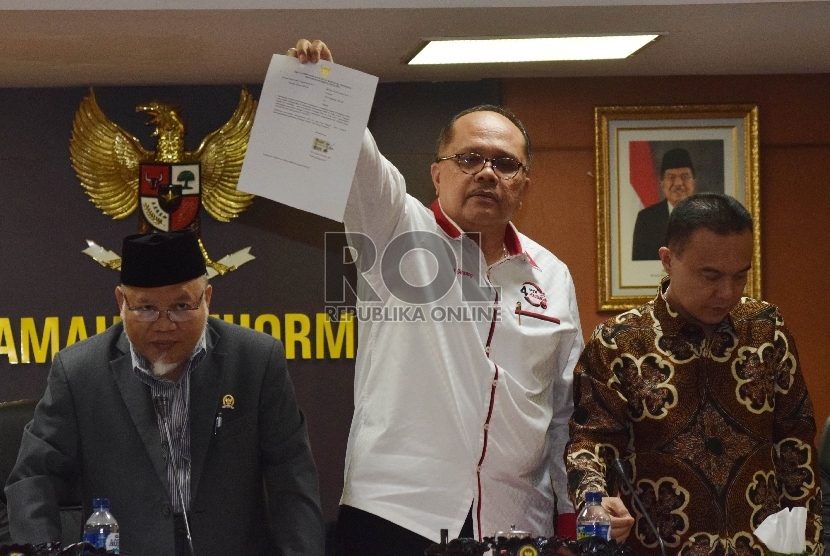  Wakil Ketua MKD Junimart Girsang (tengah) menunjukkan surat pengunduran diri Setya Novanto bersama Ketua MKD Surahman Hidayat ( kiri), dan Sufmi Dasco Ahmad(kanan)  di Kompleks Parlemen Senayan, Jakarta, Rabu (16/12).  (Republika/Rakhmawaty La'lang)