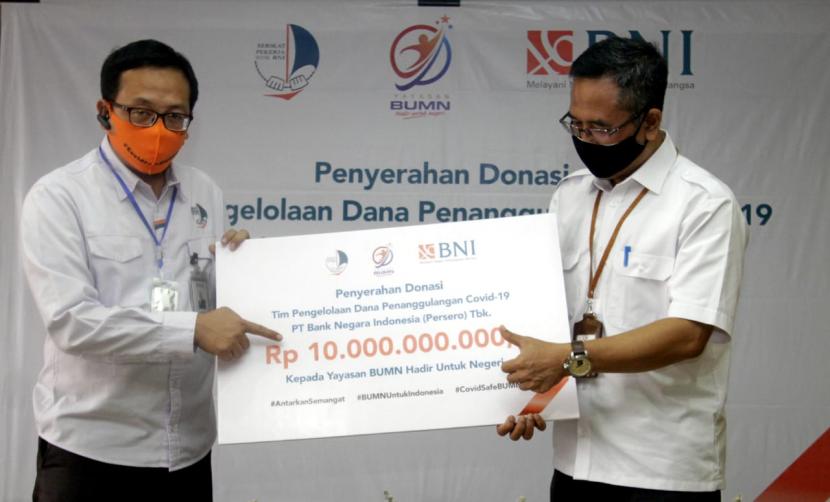 Wakil Ketua Tim Pengelolaan Dana Penanggulangan Covid-19 BNI (sekaligus Ketua Umum Dewan Pengurus Pusat Serikat Pekerja BNI) Irfan Ferdiansyah (kiri) menyerahkan secara simbolis Donasi BNI Hi-Movers kepada Ketua Pengurus Yayasan BUMN Hadir Untuk Negeri Harjawan Balanigrath (kanan) di Jakarta, Senin (15 Juni 2020). Donasi tersebut akan digunakan untuk pengadaan peralatan dan perlengkapan medis bagi masyarakat penerima di berbagai wilayah di Indonesia.