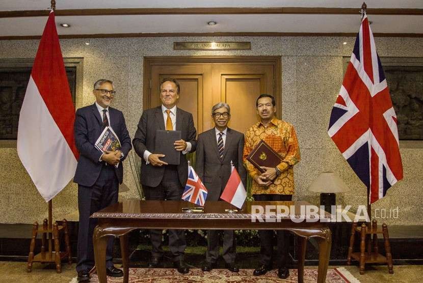 Wakil Menteri Luar Negeri A. M. Fachir (kedua kanan) bersama Duta Besar Inggris untuk Indonesia Moazzam Malik (kiri), Menteri Muda Urusan Asia Pasifik Kemlu Inggris Y.M Mark Field (kedua kiri) dan Kepala Badan Siber dan Sandi Negara Djoko Setiadi (kanan) berfoto bersama usai menandatangani MoU di Kementerian Luar Negeri, Jakarta, Selasa (14/8). 