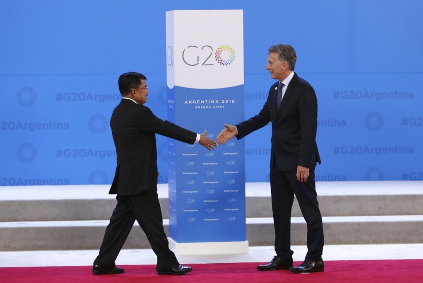 Wakil Presiden Jusuf Kala berjalan menyambut salam Presiden Argentina Mauricio Macri pada KTT G20 di Buenos Aires, Argentina, Jumat (30/11).