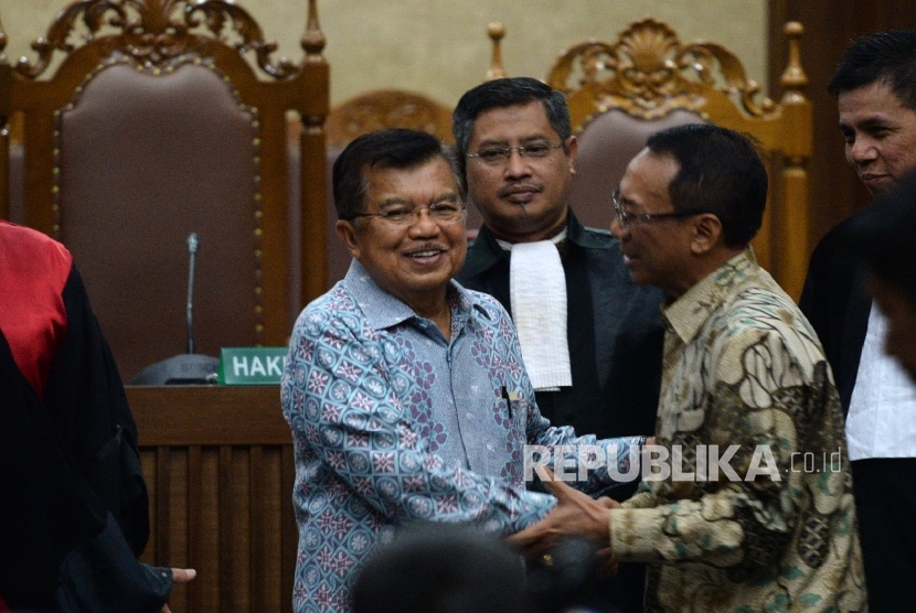 Wakil Presiden Jusuf Kalla berjabat dengan Jero Wacik usai memberikan kesaksian menjadi saksi meringankan untuk terdakwa kasus dugaan korupsi Dana Operasional Menteri (DOM) di Kementerian ESDM dan Kemenbudpar, Pengadilan Tipikor, Jakarta, Kamis (14/1).