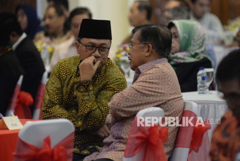 Wakil Presiden Jusuf Kalla (kanan) berbincang dengan Ketua MPR Zulkifli Hasan saat pembukaan Simposium Nasional di Kompleks Parlemen, Senayan, Jakarta, Rabu (12/7). 
