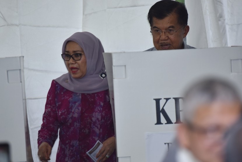 Wakil Presiden Jusuf Kalla (kanan) dan istri Mufidah Jusuf Kalla berada di bilik suara ketika memberikan hak suara pada Pilkada DKI Jakarta di TPS 3 Pulo, Kebayoran Baru, Jakarta, Rabu (15/2).