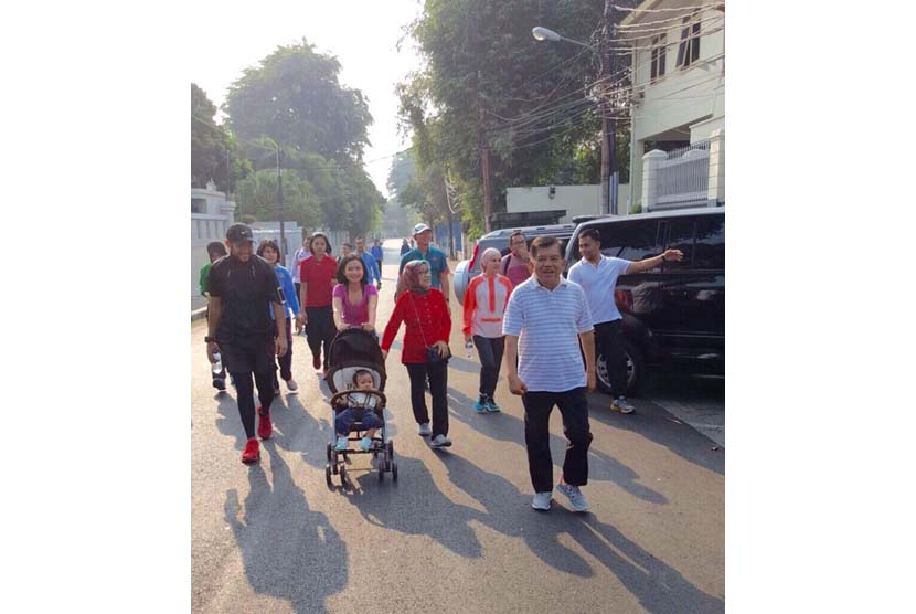 Wakil Presiden Jusuf Kalla (kanan) melakukan jogging bersama keluarga besarnya di lingkungan sekitar rumah di Taman Suropati, Jakarta, Ahad (13/9).