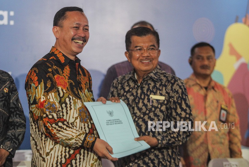 Wakil Presiden Jusuf Kalla (kanan) menerima dokumen rekomendasi dari Ketua Komnas HAM Ahmad Taufan Damanik (kiri) pada Peringatan Hari HAM Internasional 2018 di kantor Komnas HAM, Jakarta, Selasa (11/12/2018).