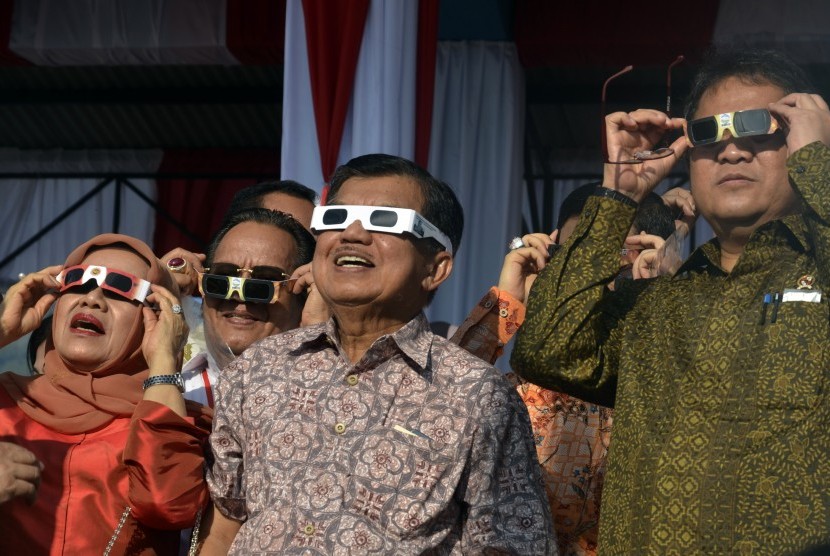 Wakil Presiden Jusuf Kalla (kedua kanan) didampingi Ibu Mufidah Jusuf Kalla (kiri) dan Menteri Komunikasi dan Informatika Rudiantara (kanan) menyaksikan Gerhana Matahari Total (GMT) di Lapangan Dolo, Kabupaten Sigi, Sulawesi Tengah, Rabu, (9/2).