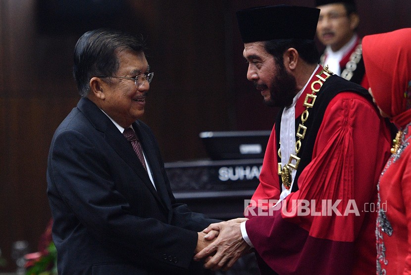 Wakil Presiden Jusuf Kalla (kiri) memberikan ucapan selamat kepada Ketua Mahkamah Konstitusi (MK) terpilih Anwar Usman usai acara pengucapan sumpah jabatan Ketua dan Wakil Ketua MK di gedung MK, Jakarta, Senin (2/4). 
