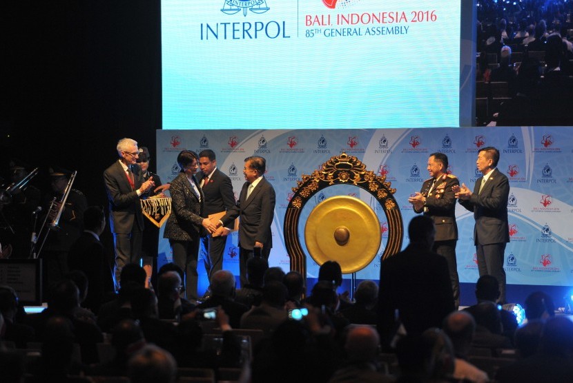 Wakil Presiden Jusuf Kalla (tengah) berjabat tangan dengan Presiden Interpol, Mireille Ballestrazzi (kedua kiri) disaksikan Sekjen Interpol Jurgen Stock (kiri), Kapolri Jendral Pol Tito Karnavian (kedua kanan) dan Gubernur Bali Made Mangku Pastika (kanan) 