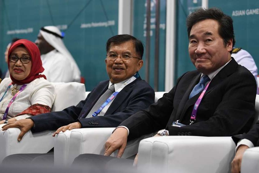 Wakil Presiden Jusuf Kalla (tengah) didampingi Ibu Mufidah Jusuf Kalla (kiri) dan Perdana Menteri Korea Selatan Lee Nak-yeon menghadiri Upacara Pembukaan Asian Games ke-18 Tahun 2018 di Stadion Utama GBK, Senayan, Jakarta, Sabtu (18/8).