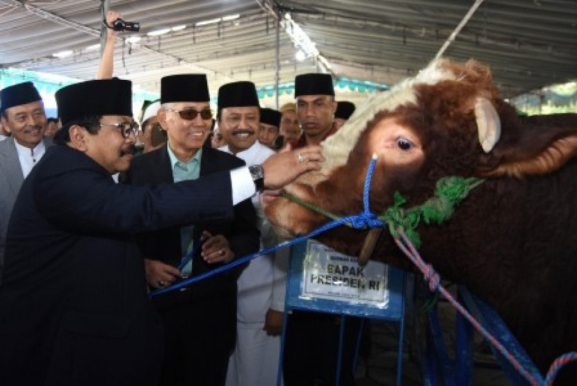 Wakil Presiden RI keenam yang juga Ketua Dewan Pembina Masjid Nasional Al-Akbar Surabaya (MAS), Try Sutrisno (kedua kiri) menerima sapi kurban Presiden RI Joko Widodo dari Gubernur Jawa Timur Soekarwo (kiri) didampingi Wakil Gubernur Jawa Timur Saifullah Y