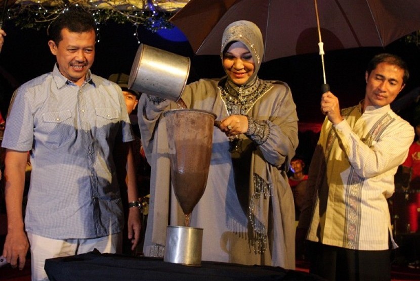 Wakil Wali Kota Banda Aceh Illiza Sa'aduddin Djamal (tengah) menyaring kopi tanda dibukanya festival kopi Aceh di Taman Sari, Banda Aceh, Jumat (25/11).