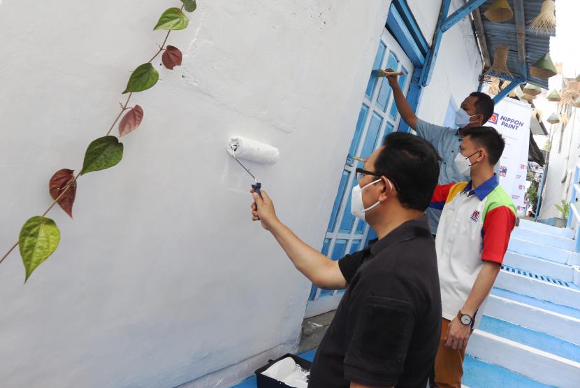 Wakil Walikota Yogyakarta, Drs. Heroe Poerwadi  (kiri) dan Topan Wijaksono sebagai Area Sales Manager Nippon Paint Indonesia secara simbolis melakukan pengecatan di salah satu hunian di kali Code  1001 Yogyakarta