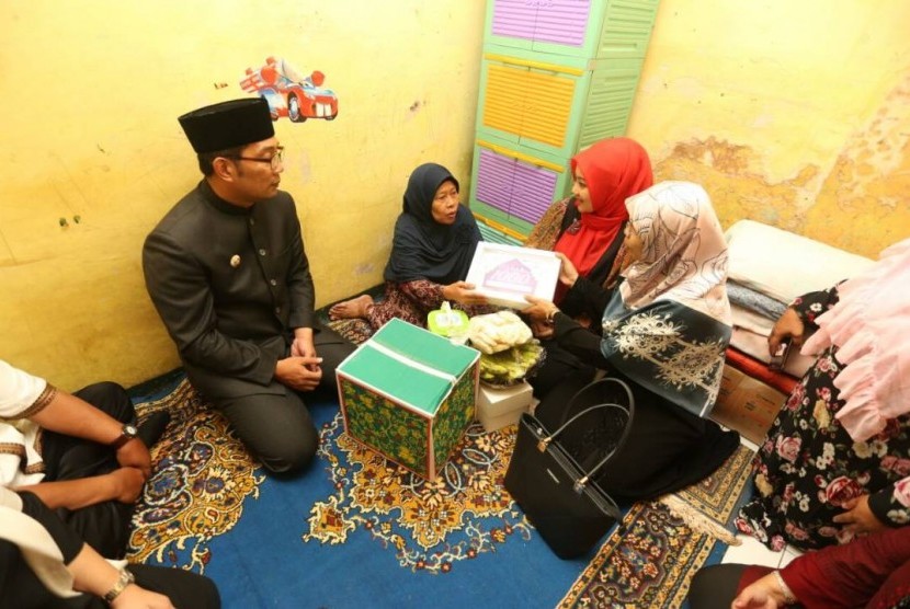 Wali Kota Bandung H M Ridwan Kamil (berpeci) didampingi istri Atalia Praratya mendatangi keluarga dhuafa dalam rangkaian kegiatan Buka Berkah di Kecamatan Ujungberung, Kota Bandung, Senin (29/5).  