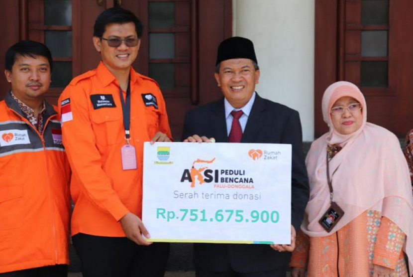 Wali Kota Bandung, Oded Muhammad Danial menyerahkan bantuan untuk Palu kepada Irvan Nugraha, Chief Marketing Officer Rumah Zakat.