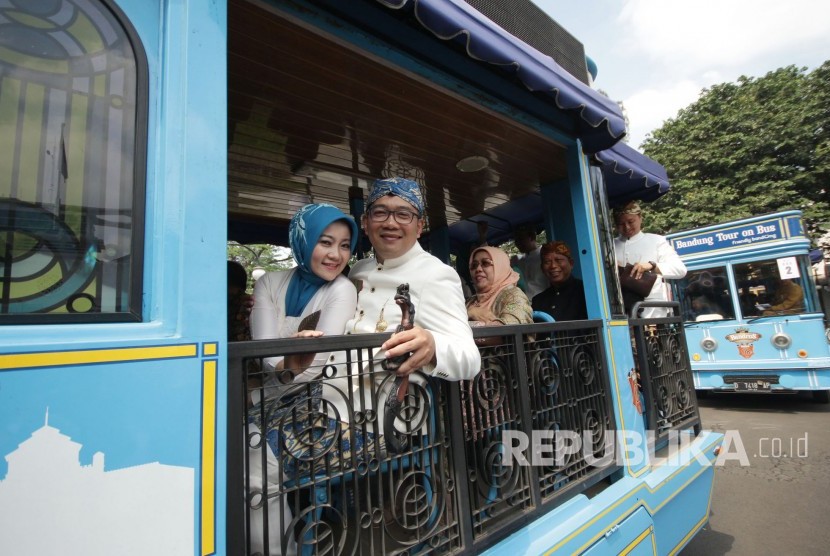 Wali Kota Bandung Ridwan Kamil beserta istri dan para pejabat lainnya menaiki kendaraan Bandung Tour on Bus (Bandros) menuju DPRD Kota Bandung usai upacara Hari Jadi Kota Bandung (HJKB) ke-207, di Balai Kota Bandung, Senin (25/9).