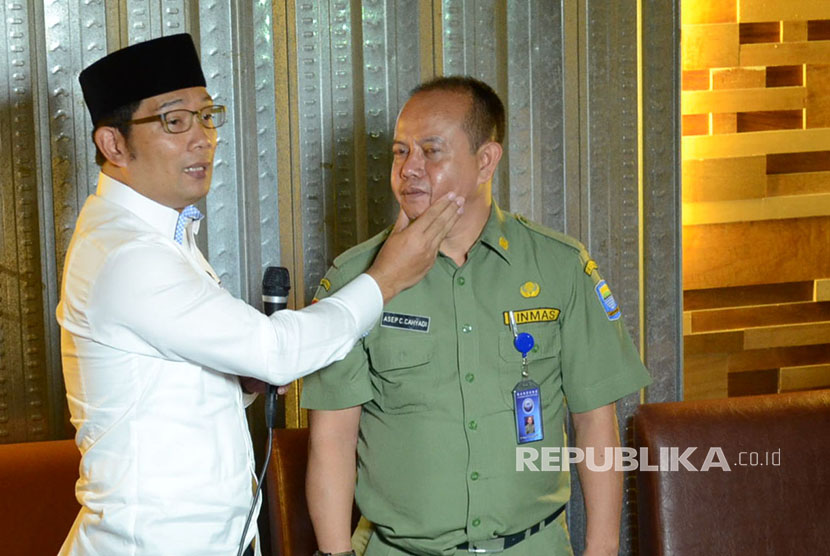 Wali Kota Bandung Ridwan kamil memperagakan cara memegang pipi saat mengingatkan sopir angkot omprengan yang membandel, di Kota Bandung, Senin (21/3).